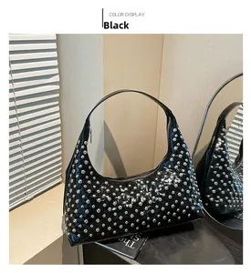 Detail der schwarzen Lackleder-Achseltasche mit silbernen Rundnieten und Mondform