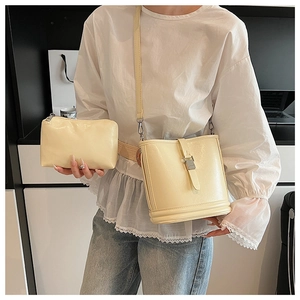 Détail du sac seau crème et de sa pochette zippée assortie en cuir synthétique doux
