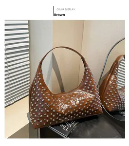Nahaufnahme braune Lackleder Hobo-Tasche mit silbernen Metallnieten vor Holz-Hintergrund