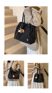 Detail of black drawstring tote bag with clover logo and baseball themed bag charm