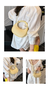 Detail of woven texture and round handle on a minimalist beige crescent handbag