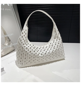 Detail der weißen Hobo-Tasche aus Leder mit polierten silbernen Nieten und Reißverschluss