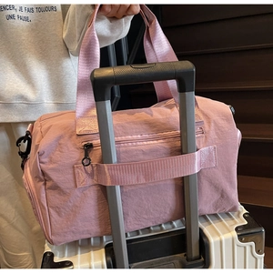 Detail of travel bag with trolley sleeve attached to a white suitcase handle