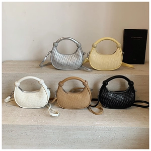 Detailed collection of five woven hobo bags in various colors on a stone steps display