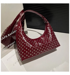 Detailansicht der burgunderroten Hobo-Tasche mit silbernen Metallnieten und Glanzfinish