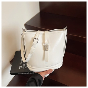 Détail du sac seau blanc avec boucle argentée et texture en cuir de haute qualité