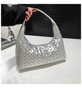 Nahaufnahme der silbernen Hobo-Tasche mit runden Metallnieten und schickem Punk-Finish