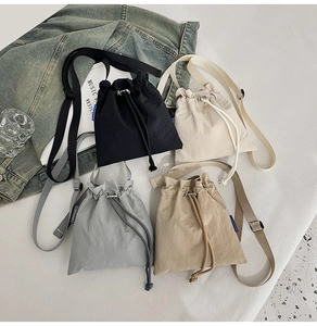 Detailed display of assorted nylon bucket bags in black, beige, grey, and khaki colors