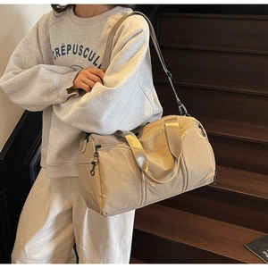 Beige waterproof nylon travel bag with side zipper pocket and adjustable strap