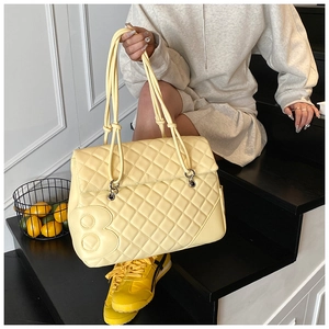 Dettaglio borsa shopper trapuntata giallo chiaro con anelli d'argento e motivo a 8