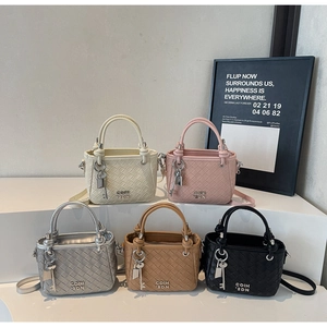 Detail view of woven leather bucket bags in five colors with metal logo and key charm