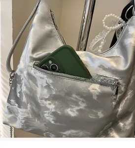 Detail showing functional front zipper pocket of silver cloud texture tote bag with chain