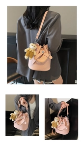 Rosa Beuteltasche mit Lychee-Muster, Lederriemen und niedlichem Bärenanhänger im Detail