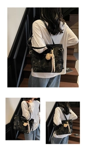 Detail view of black textured tote bag with cute bear charm and checkered scarf accent