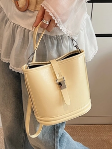 Sac seau élégant en cuir jaune crème avec fermoir argenté et bandoulière réglable