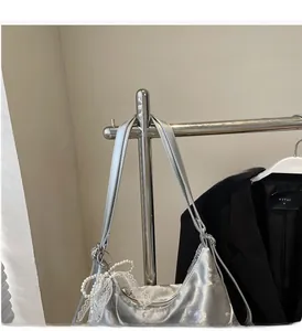 Close-up of silver satin tote bag featuring elegant pearl and lace charm decoration