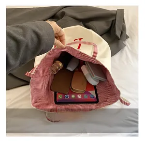 Detail view of large canvas tote bag showing spacious interior with red striped lining