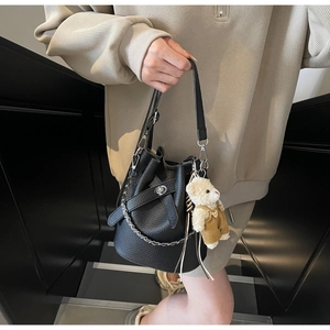 Detail der schwarzen Beuteltasche aus Lychee-Leder mit Silberkette und Teddybär-Anhänger