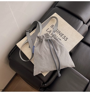 Detail view of the gray nylon crossbody phone bag with adjustable strap and NINGNING label