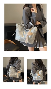 Detail of silver metallic tote bag featuring plush bear charm and side drawstring texture