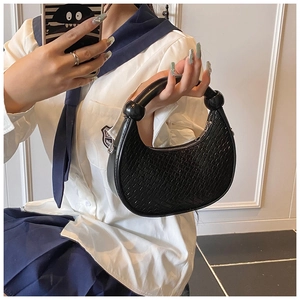 Detail of black faux crocodile pattern bag featuring unique large bead top handle and zipper