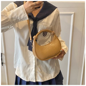 Detail of khaki woven texture moon bag featuring a round handle and slim shoulder strap