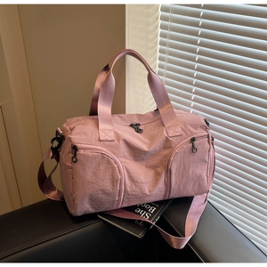 Detail of dusty rose travel bag with fabric texture and side shoe compartment for fitness