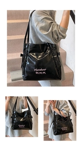 Detail of glossy black tote bag with pink butterfly embroidery and side ribbon design