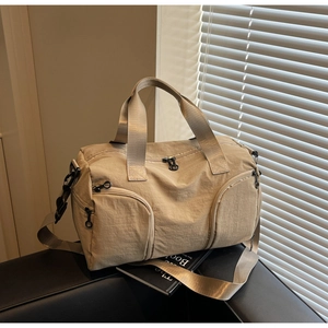 Detail of beige travel bag with unique curved zipper pockets and sturdy carry handles