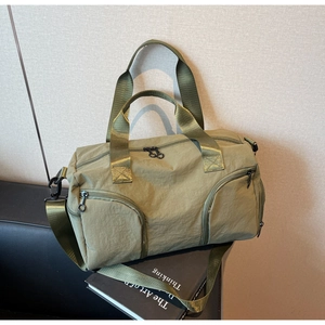 Detail of army green travel bag featuring shoe compartment and adjustable shoulder strap