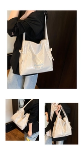 Close-up of beige glossy tote bag with Mooduo embroidery and decorative blue bows