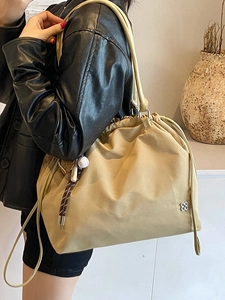 Minimalist khaki drawstring tote bag with silver floral logo and baseball charm