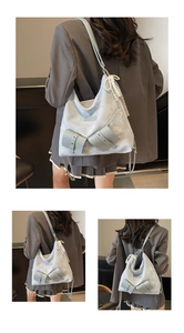 Detail view of light blue tote bag with pearl pendant, lace trim and metal chain strap