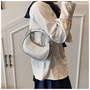 Detail showing the silver woven crescent bag with unique round beads and metal finish