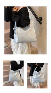 Detail view of silver tote bag featuring Mooduo logo and 3D bow decoration accents