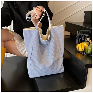 Detail of blue and white striped canvas tote bag showing durable texture and strap system