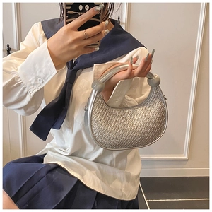 Detail of silver woven hobo bag with metallic finish and sphere handle ornaments