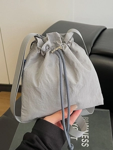 Grey nylon drawstring crossbody bag with adjustable strap for casual outdoor travel