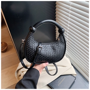 Close-up of black woven half-moon handbag featuring a thick round handle and PU texture