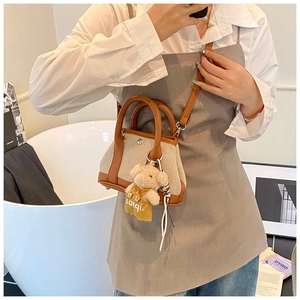 Mini canvas bucket bag with brown leather trim and cute teddy bear charm detail