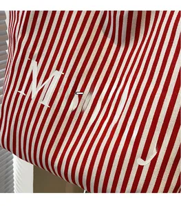Detailed macro view of red and white striped canvas tote with Monday letter print