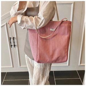 Close-up of a large red and white striped tote bag with YOU'RE SO CUTE woven label