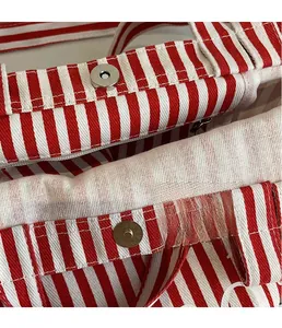 Detail of magnetic snap closure and zipper on the red and white striped canvas tote bag