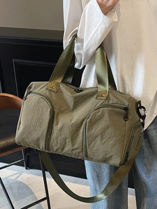 Olive green large capacity travel bag with shoe compartment shown being carried by a model