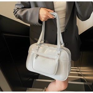 Detail of white faux leather backpack with Noronoro logo on the zippered front pocket