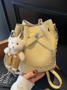 Hellgelbe Beuteltasche aus Leder mit Lychee-Narbung, Silberkette und süßem Bärenanhänger