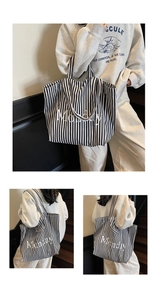 Detail view of a large canvas tote bag with black and white stripes and Monday lettering