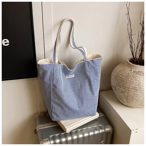 Detail of blue and white striped canvas tote bag featuring You're So Cute woven label