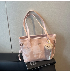 Close-up of pink marble pattern tote bag with MIKAXIQI logo and brown teddy bear charm