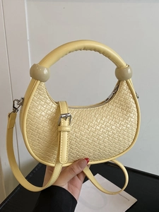 Minimalist cream woven dumpling bag with beaded round handles and adjustable shoulder strap
